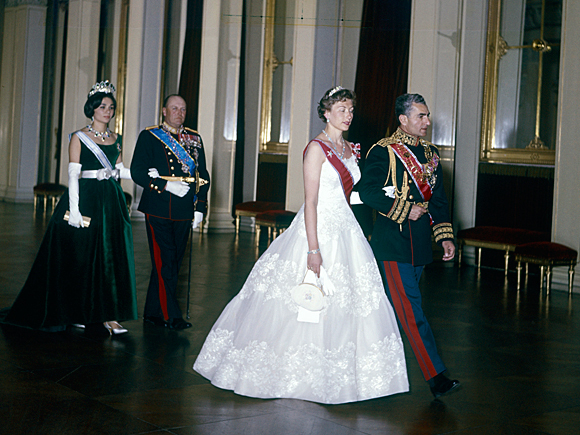 Som landets førstedame hadde Prinsesse Astrid rollen som vertinne under statsbesøk. Her er hun på vei inn til gallamiddag med Sjahen av Persia som besøkte Norge i 1961. Bak følger Kong Olav og Dronning Farah Diba (Foto: NTB / Scanpix)